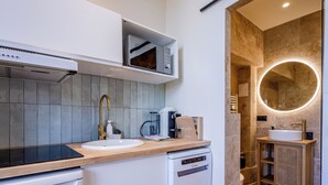 A modern kitchen with a built-in oven, a coffee machine, and a dishwasher. - (034) Le Cocon Méditerranéen (Antibes)