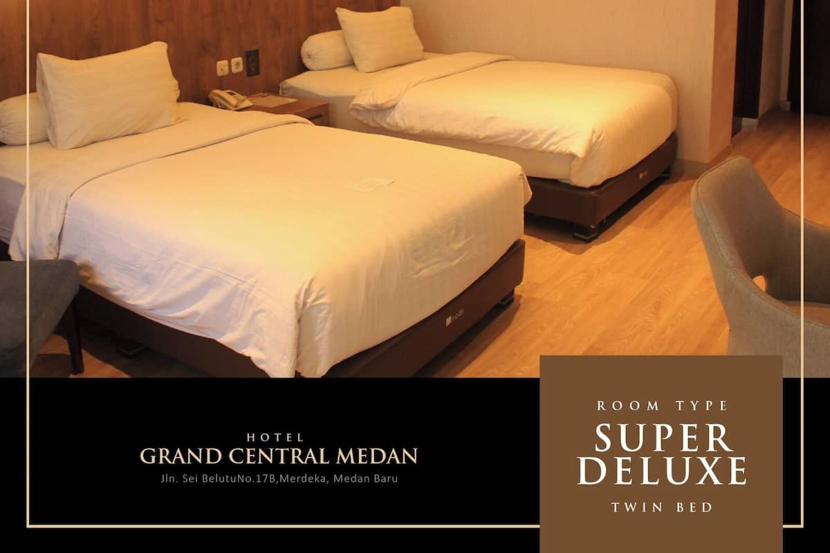 A hotel room with twin beds, wooden headboard, and a palm leaf design on the wall.