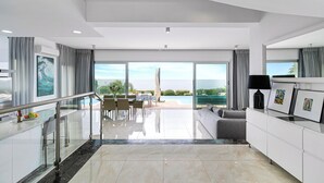 Une chambre d’hôtel moderne dotée d’un balcon, d’un coin repas et d’un espace de vie.