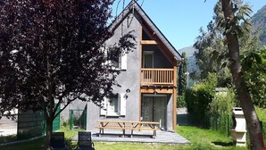 Un bâtiment à deux étages doté d’un balcon, d’une table de pique-nique et d’une cour clôturée.