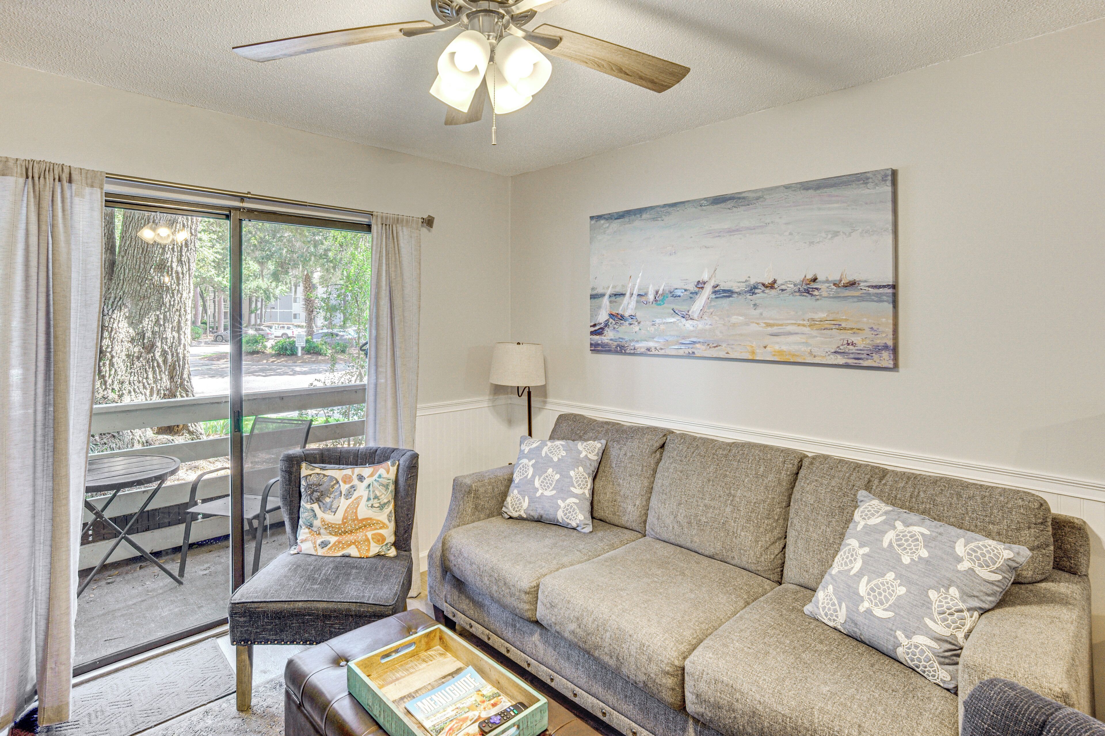 A living room with a sofa, a table, and a painting on the wall.