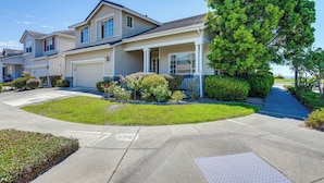 A row of single-family homes with attached garages, a well-maintained lawn, and a sidewalk leading to the entrance. - 1 Block to Bay: Pet-friendly Retreat in Alameda! (Alameda)