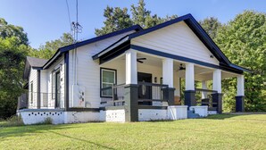 A single-story house with a porch, white siding, and a dark roof.
