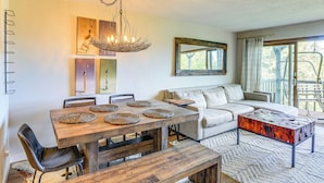 A dining area with a wooden table, benches, and chairs. There is a sofa and a coffee table in the living area. - Families Welcome! Sugar Mtn Gem: Golf, Hike & Ski (Banner Elk)