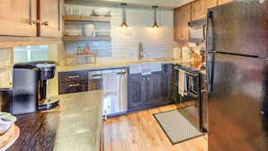 A modern kitchen with wooden cabinets, stainless steel appliances, and pendant lighting. - Families Welcome! Sugar Mtn Gem: Golf, Hike & Ski (Banner Elk)