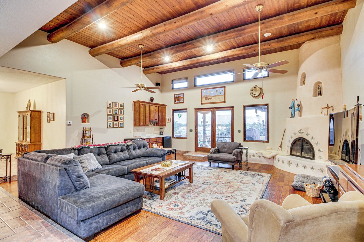 A spacious living room with a large sectional sofa, a fireplace, and a ceiling fan.
