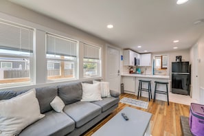 A modern living room with a grey sofa, a coffee table, and a remote control.