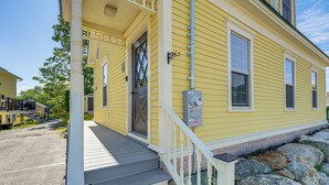 A yellow building with a porch, a door, and a utility box. - Charming Apt w/ Shared Outdoor Space in Lisbon! (Lisbon)