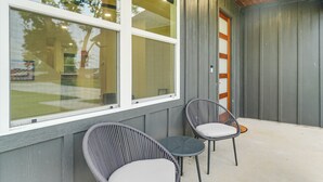 A room with two wicker chairs and a small table, a large window, and a wooden ceiling. - Lake-view Retreat w/ Games & Yard in Daingerfield (Daingerfield)