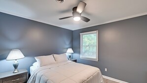 A bedroom with a bed, two bedside tables with lamps, a ceiling fan, and a window with blinds. - Private Patio: Apt 6 Mi to Cheraw State Park! (Cheraw)