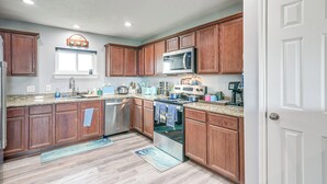 A kitchen with wooden cabinets, stainless steel appliances, and a window.