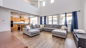 A spacious living room with a sectional sofa, a wooden dining table, and a kitchen in the background. - 1 Mi to Golf! Spacious & Modern Home in Dinuba (Dinuba)