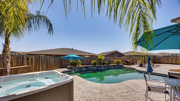 A backyard with a swimming pool, hot tub, and patio furniture. - 1 Mi to Golf! Spacious & Modern Home in Dinuba (Dinuba)