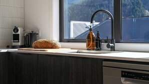 A kitchen with a loaf of bread on the counter, a bottle of hand soap, and a coffee maker. - Central Escape - A modern townhouse with mountain and lake views in the heart of Queenstown. (Queenstown)