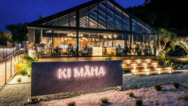 A modern building with a sign reading 'KI MAHA' and a glass facade.