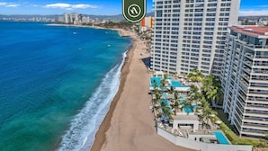 Ein Strandhotel mit Poolbereich, Strand und Meerblick.