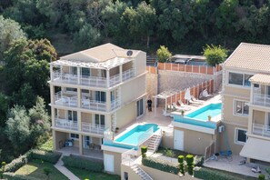 A multi-story hotel with balconies, a swimming pool, and a garden area. - Pantokrator Private Pool Gem - Lux Villa in Corfu (Agios Mattheos)