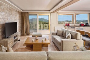 A modern living room with a flat-screen TV, a wooden coffee table, and a beige sofa.