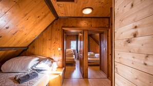 A wooden cabin with a loft bedroom, a small bathroom, and a narrow hallway leading to another room. - Chalet 'Jarrier' with Mountain View, Private Terrace and Private Garden (Jarrier)