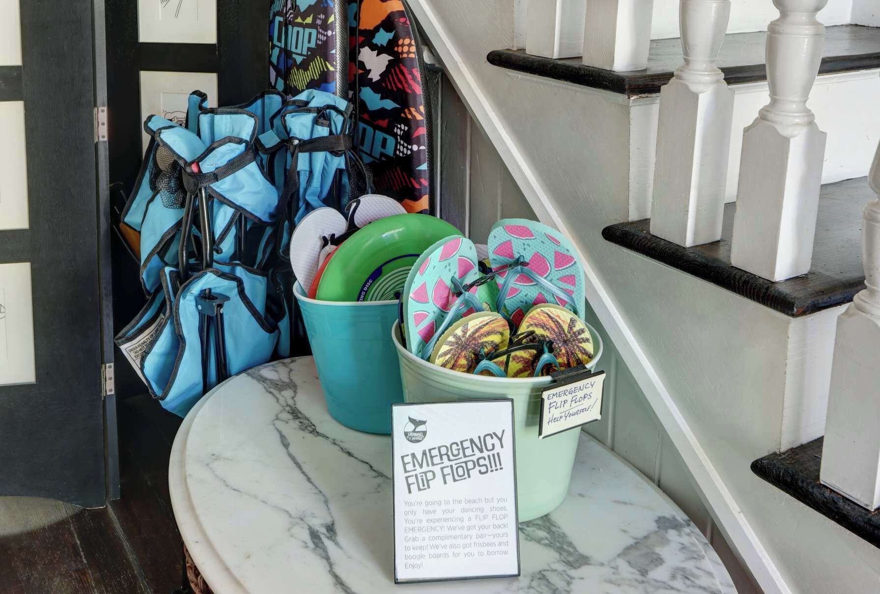 A marble counter with emergency flip flops and a bucket of shoes.