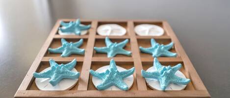 Una bandeja de madera con varios compartimentos, cada uno con una base circular blanca y una figurita de estrella de mar azul.