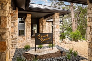 A stone building with a sign reading "Chasing Summer Lake Travis."