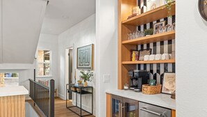 Eine moderne Küche mit Holzböden, einer Kaffeemaschine und einem Kühlschrank.