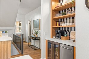 A modern kitchen with wooden shelves, a coffee machine, and a refrigerator. - Chasing Summer - Private Lakefront Luxury on Lake (Point Venture)