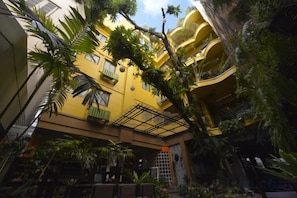 A multi-story building with balconies, surrounded by lush greenery. - Sourire at Rattanakosin Island (Bangkok)