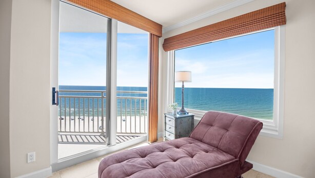 A bedroom with a bed, a nightstand, a lamp, and a view of the ocean through a large window. - NEW LISTING!!! Seaspray East 922 - Beach Front - HASSLE-FREE CHECK OUT (Perdido Key)
