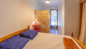 A bedroom with a bed, pillows, a nightstand, a lamp, and a wardrobe. - Holiday Home 'Gîte 1 - La Tour' with Lake View and Wi-Fi (Saint-Sauveur de Cruzières)