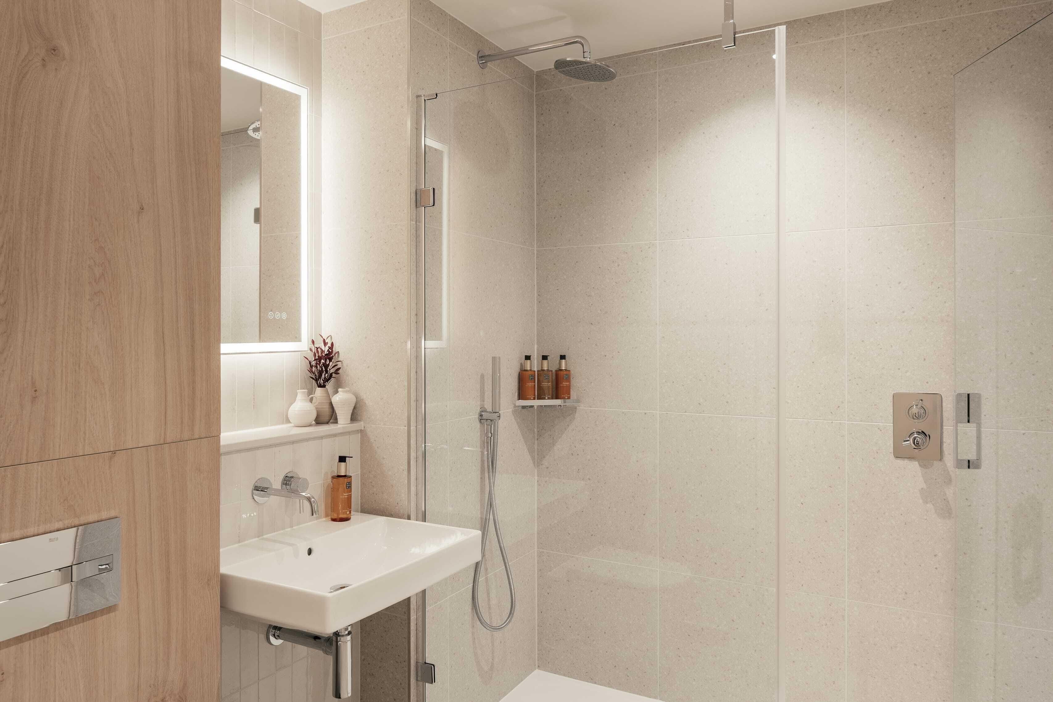 A modern bathroom with a shower, sink, and a mirror.