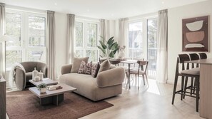 Un salon moderne avec un canapé, une table basse et un coin repas.