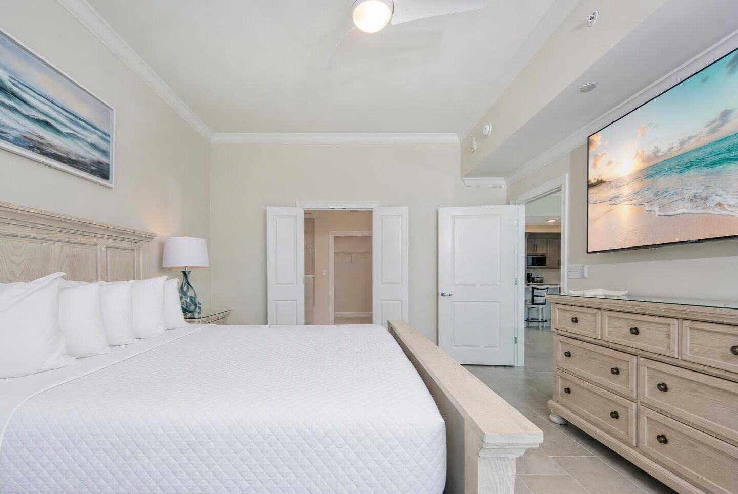 A bedroom with a bed, a dresser, and a television.
