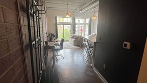 Une pièce spacieuse avec un mur en briques, un banc, une table et un canapé.