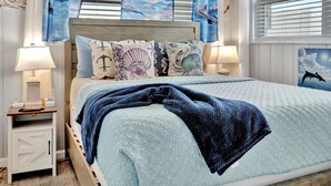 A bedroom with a bed, nightstands, and a window with blinds. - Seashell Suite 1B Pet Friendly Waterfront Dock (Treasure Island)