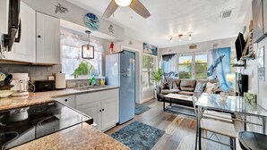 A modern kitchen with a built-in stove, white cabinets, and a blue refrigerator. - Seashell Suite 1B Pet Friendly Waterfront Dock (Treasure Island)
