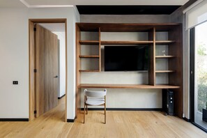 A modern room with a built-in TV shelf, a chair, and a computer. - w Fabulous 1BR With Elegant Balcony in Roma Nte (Mexico City)