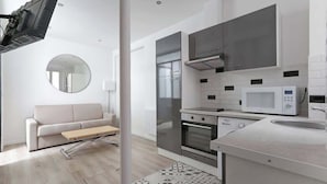 Una cocina moderna con horno empotrado, microondas y refrigerador de acero inoxidable.