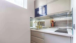 Een moderne keuken met een inbouwoven, een roestvrijstalen spoelbak en een decoratieve vaas.