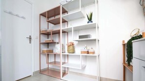 Een witte kast met meerdere planken en een deur.