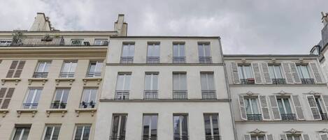 A row of three-story buildings with uniform architectural style, featuring multiple windows and balconies.