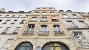 Ein mehrstöckiges Gebäude mit Bogenfenstern und Balkonen.