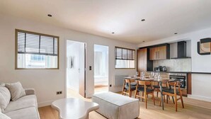 En moderne lejlighed med opholdsstue, spiseområde og køkken.