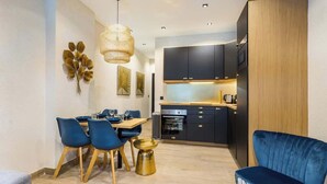 A compact living space with a dining area, kitchenette, and a blue armchair. - Nation/Charonne II : Magnifique Appartement 1BR-4P (Paris)