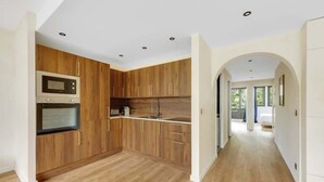 Una cucina moderna con mobili in legno, elettrodomestici in acciaio inossidabile e un'isola centrale.