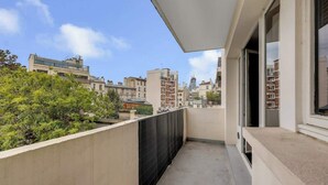 Un balcone con vista sugli edifici e alberi circostanti.