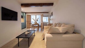 Ett modernt vardagsrum med en soffa, ett soffbord och en tv som är monterad på väggen.