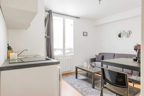 A compact living space with a kitchenette, a dining area, and a sofa.