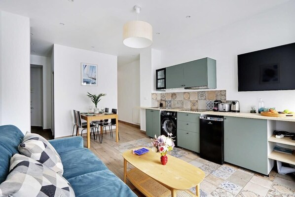 Een modern appartement met een woonkamer, eethoek en keuken.